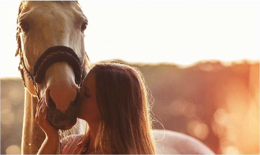 young women kissing her horse